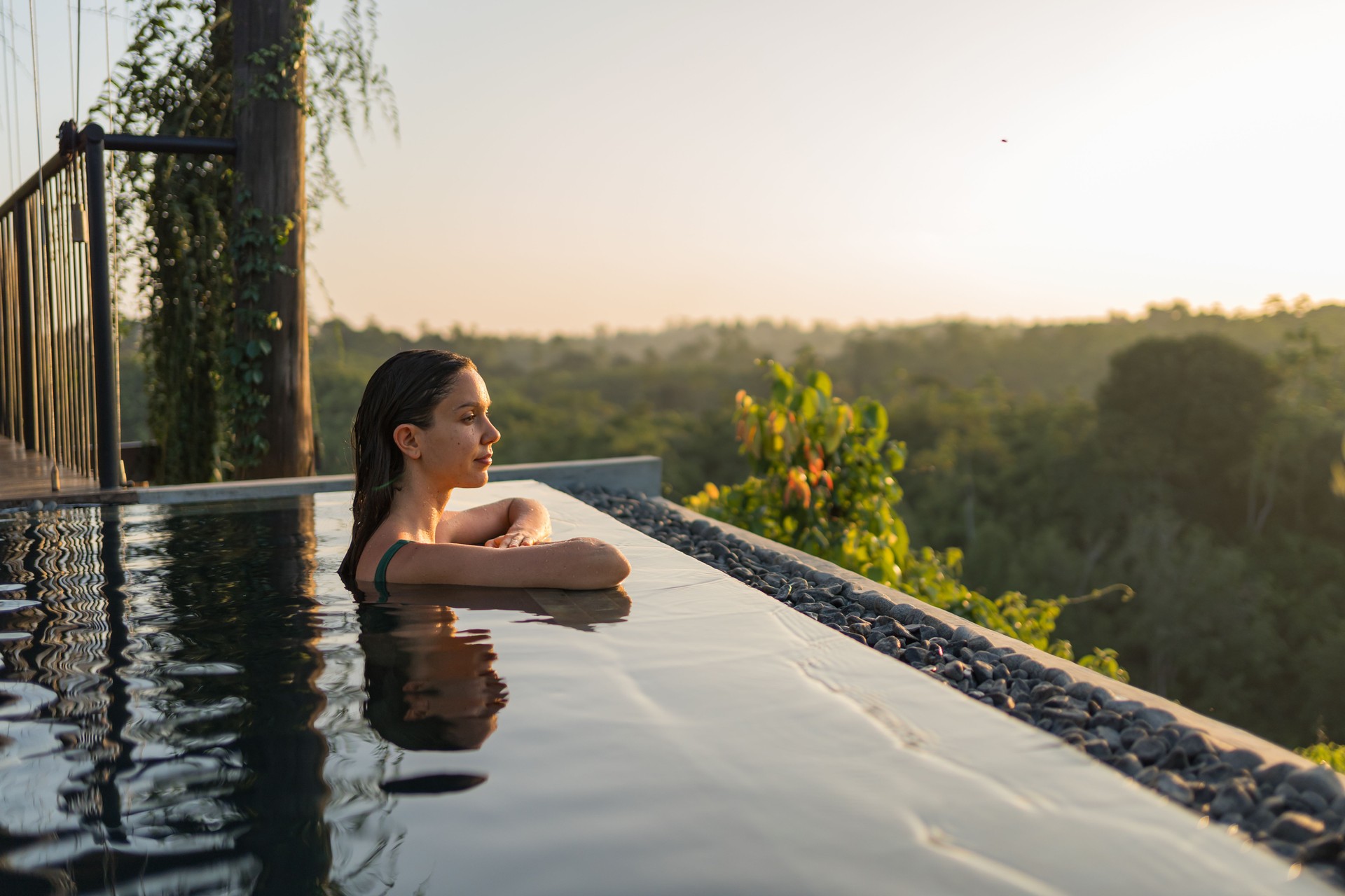 Young woman relaxes on edge of swimming pool